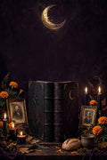 The Ancestor Season Bundle: two dark grimoires on a Samhain ancestor altar with framed photographs, black and red candles, marigolds and bread